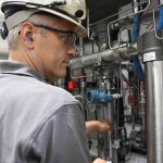 Fluid Aire Dynamics employee inspecting equipment