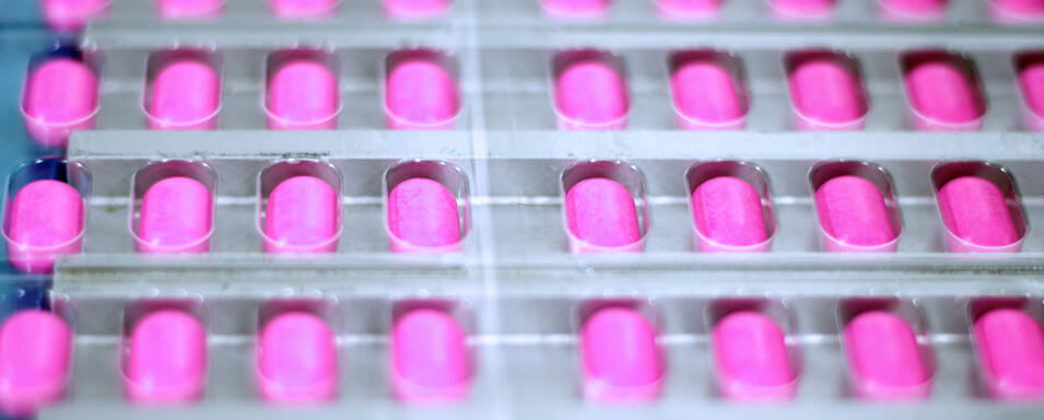 Pink pills being manufactured in a pharmaceutical plant