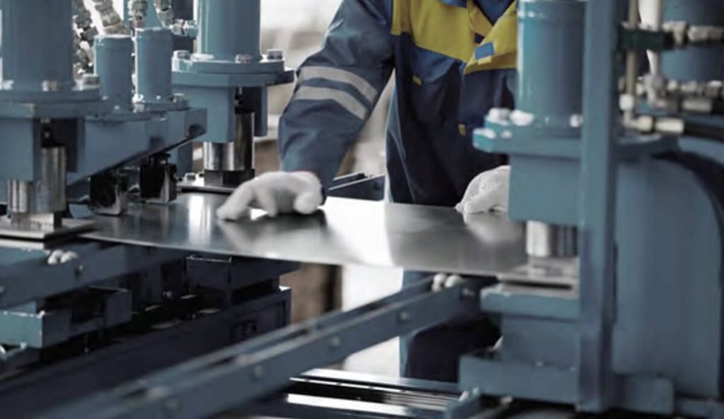 Industrial worker using tools on sheet metal