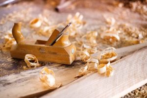 Image of woodworking planer with wooden planks and wood shavings